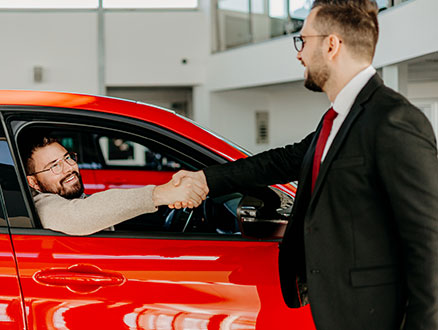 Man shaking hands with car salesman